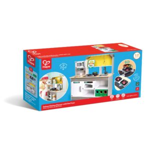 A boxed Hape ‘Deluxe Kitchen Playset with Fan Fryer’ for ages 3–8, featuring a toy kitchen with stove, oven, microwave, sink, and storage, plus 15 accessories. The packaging shows children playing with the set and highlights the fan‑fryer feature with sound and motion.