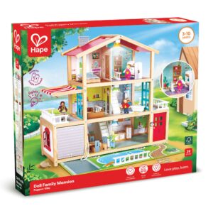 A boxed Hape ‘Doll Family Mansion’ playset for ages 3–10, showing a large multi‑story wooden dollhouse with furnished rooms, family figures, and working lights. The packaging notes that the 29‑piece set supports emotional, social, and creative development and includes AAA batteries.