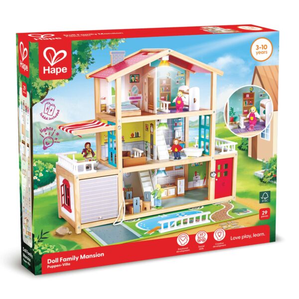 A boxed Hape ‘Doll Family Mansion’ playset for ages 3–10, showing a large multi‑story wooden dollhouse with furnished rooms, family figures, and working lights. The packaging notes that the 29‑piece set supports emotional, social, and creative development and includes AAA batteries.
